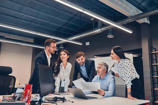 Young co-workers discussing new contract with gray-haired boss in office — Stock Photo, Image