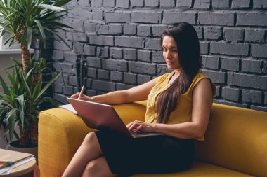 Okuma yazma bilirken notlar alan mutlu ofis çalışanı.