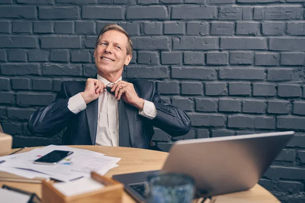 Handsome elderly male person touching his tie — Stock Photo, Image