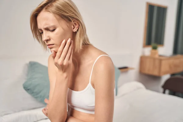 Depressieve jonge blonde vrouw met een kiespijn — Stockfoto