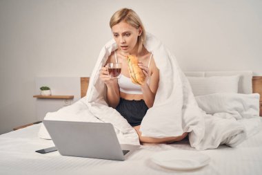 Bilgisayarında gerilim filmi izleyen korkmuş bir kadın.