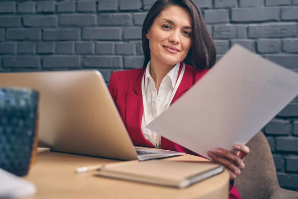 Nöjd brunett kvinna som arbetar på kontoret — Stockfoto