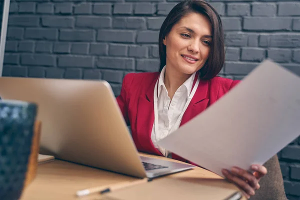 Encantadora joven mujer mirando sus documentos — Foto de Stock