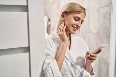 Elinde akıllı telefon tutan bir kadın.