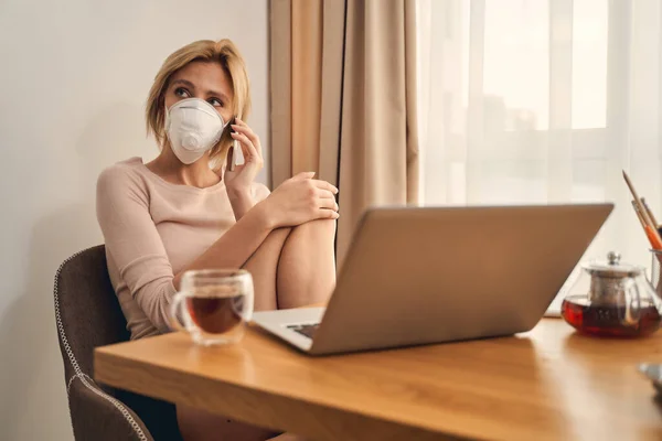 Mujer triste con un teléfono mirando hacia otro lado — Foto de Stock