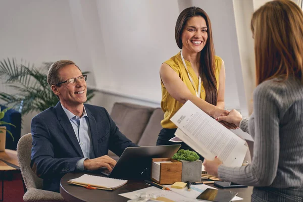 Positive delighted young assistant welcoming business partner — Stock Photo, Image