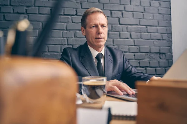 Snäll äldre man arbetar medveten på sin uppgift — Stockfoto