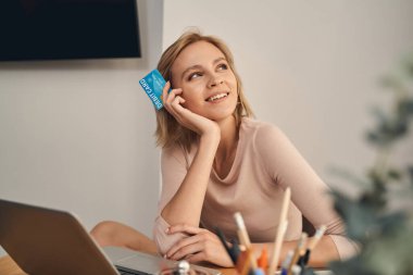 Kartı olan mutlu bir kadın başka tarafa bakıyor.