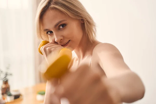 Sportswoman doing an arm exercise with dumbbells — Stock Photo, Image
