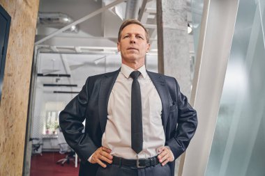 Konsantre ofis çalışanı doğrudan kameraya bakıyor.