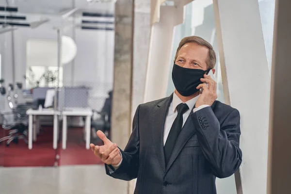 Persona masculina amable hablando por teléfono en el trabajo —  Fotos de Stock