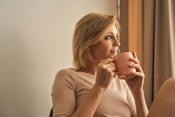 Agradable dama de pelo corto sosteniendo una taza de té — Foto de Stock