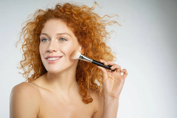 Veselý kudrnatý žena dělá přírodní make-up — Stock fotografie