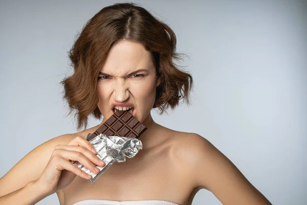 Jolly jonge vrouw genieten van eten zwarte chocolade — Stockfoto