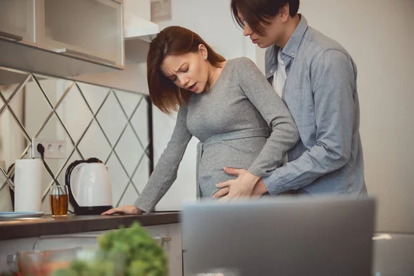 집에서 예상 치 못한 고통 스러운 진통 과 남편 이 근처에 있는 모습 — 스톡 사진