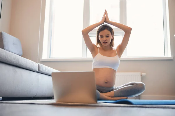 Nyfiken dam gör yoga med online lektioner hemma — Stockfoto
