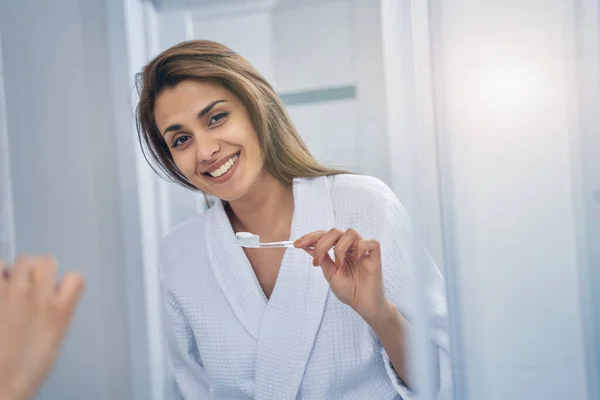 Charmig ung kvinna borsta tänderna i badrummet — Stockfoto