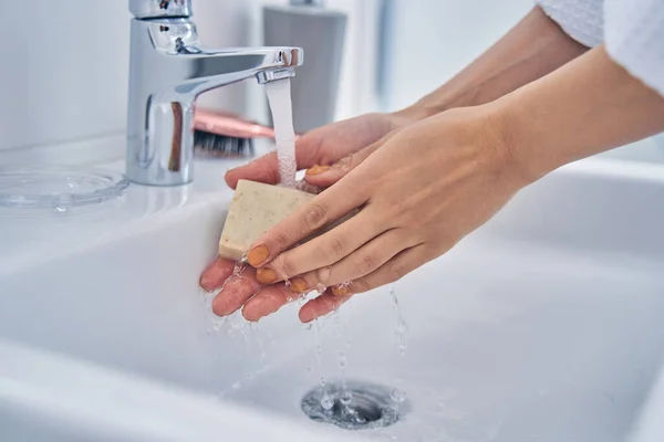 Wanita muda mencuci tangan dengan sabun di kamar mandi — Stok Foto