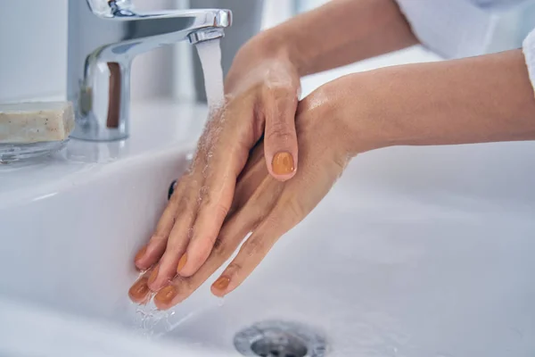 Mujer joven lavándose las manos en el baño en casa —  Fotos de Stock