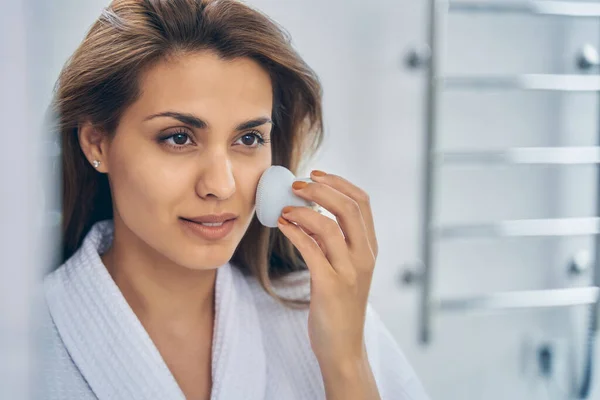 Mujer joven atractiva usando cepillo de limpieza facial —  Fotos de Stock