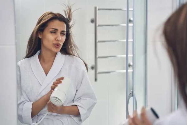 Bájos fiatal nő használ hajszárító a fürdőszobában — Stock Fotó