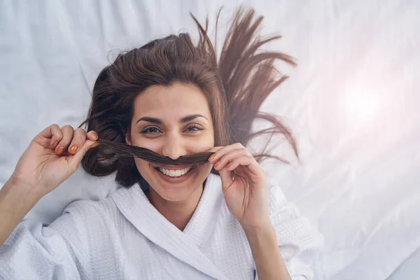 Joyeuse jeune femme jouant avec les cheveux et s'amusant à la maison — Photo