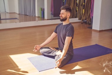 Yakışıklı genç adam gözleri kapalı meditasyon yapıyor.