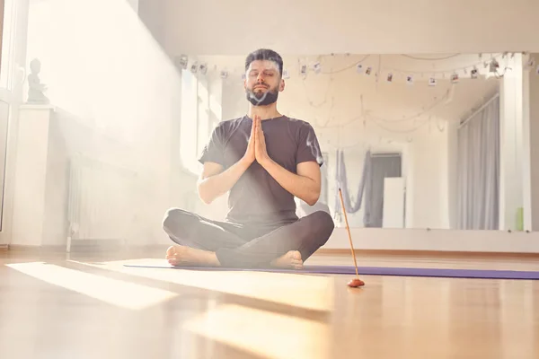 Bonito jovem meditando no estúdio de ioga — Fotografia de Stock