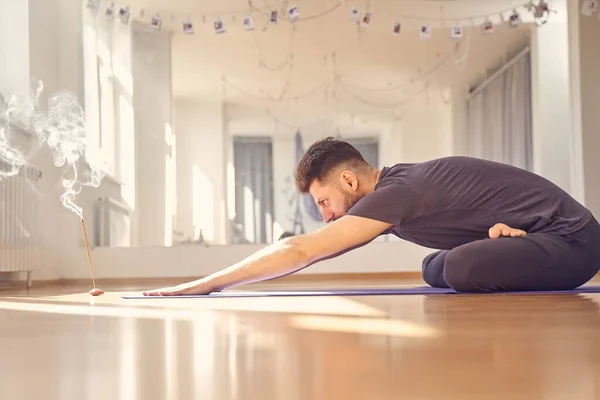 Barbudo jovem fazendo exercício no estúdio de ioga — Fotografia de Stock