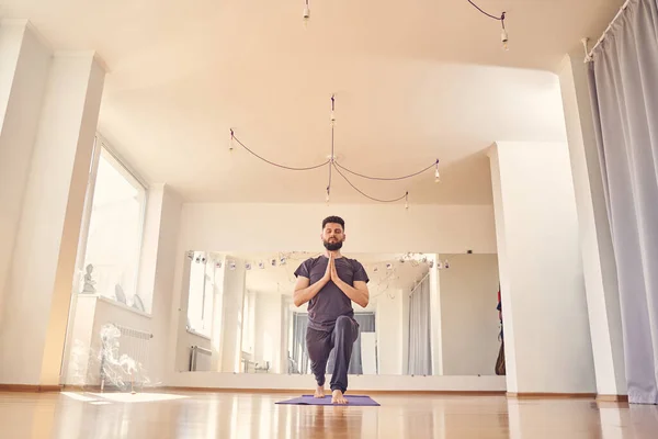 Lugn ung man utövar yoga i studio — Stockfoto