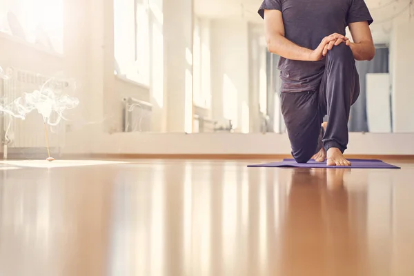 Young man standing in yoga position on yoga mat — ストック写真