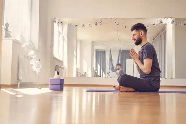 Hombre joven guapo usando la cámara robótica inalámbrica durante la sesión de yoga —  Fotos de Stock