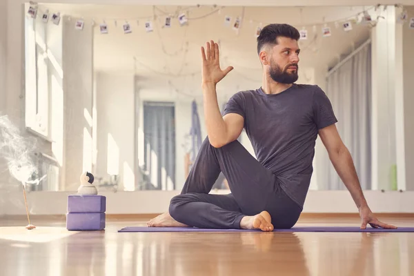 Stilig ung man gör hälften herre över fiskar yoga pose — Stockfoto