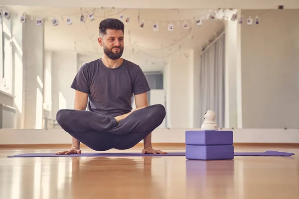 Guapo joven haciendo levantado loto o pose escala — Foto de Stock