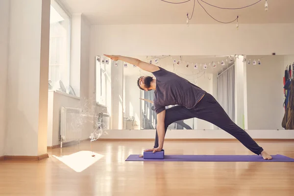 Atlético joven haciendo ejercicio con bloques de yoga —  Fotos de Stock