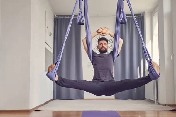 Schöner junger Mann macht luftige Yoga-Übungen — Stockfoto