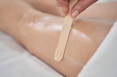 Kadının bacağına krem sürdüm ve kozmetik uzmanının eline sürdüm.