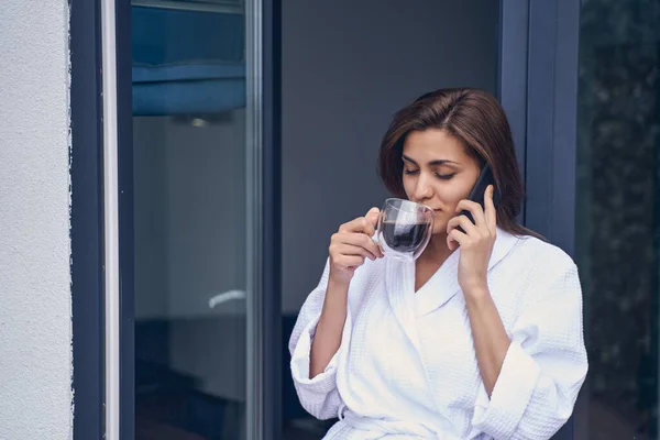 Encantadora mujer bebiendo café y hablando por teléfono móvil —  Fotos de Stock