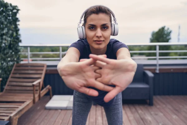 Attractive young woman in headphones working out outdoors — Stock Photo, Image