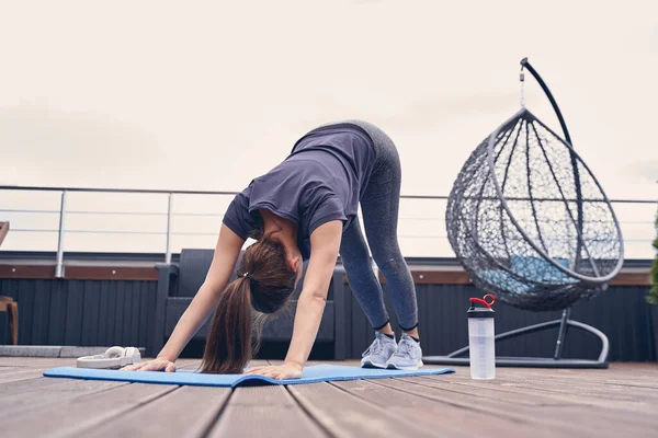Jovem desportiva praticando ioga no terraço — Fotografia de Stock