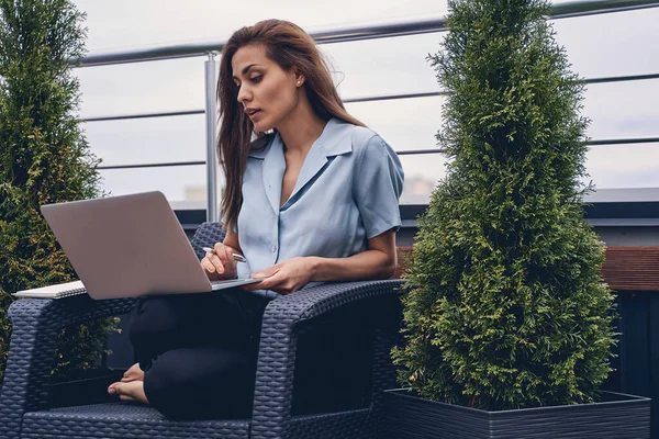 Hermosa mujer joven utilizando el ordenador portátil en la terraza de la azotea —  Fotos de Stock