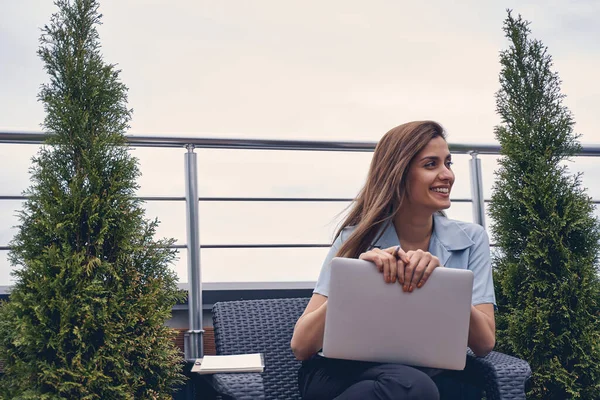 Joven alegre usando el ordenador portátil en la terraza de la azotea —  Fotos de Stock