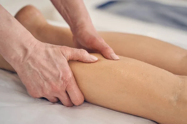 Aceite de masaje en la piel del cliente y terapeuta foto de cerca — Foto de Stock