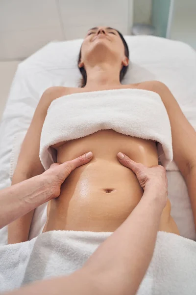 Trevlig massage av magen i spa salong för ung kvinna — Stockfoto