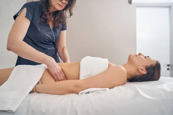 Massage Therapeut vorsichtig berühren Hüften der jungen Dame — Stockfoto