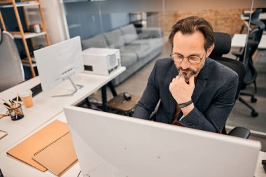 Yorgunluktan bitkin düşmüş yönetici ofisinde oturuyor.