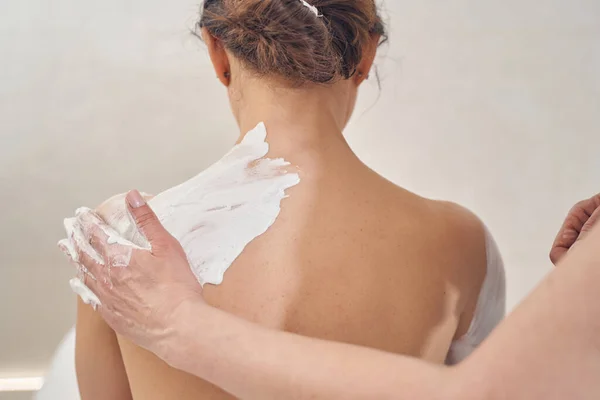 Процедура по уходу за кожей из натуральной белой глины в салоне красоты — стоковое фото