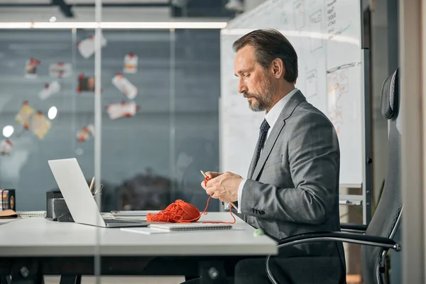 Hombre carismático aprendiendo crocket hook en la oficina — Foto de Stock