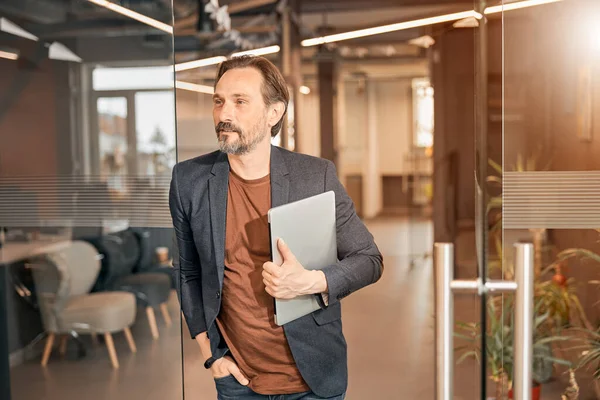 Gelukkig lachende man met een baard met laptop in de hand — Stockfoto