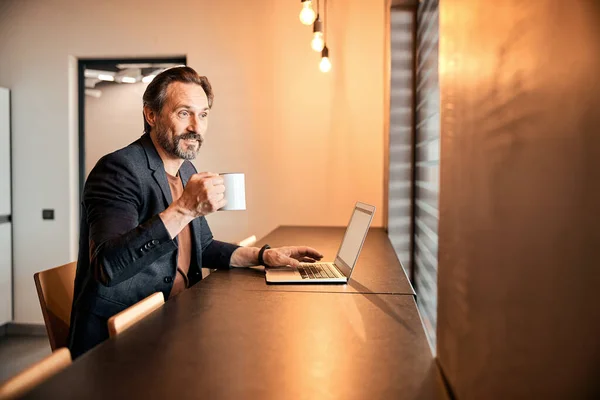 Empresário sentado na mesa do escritório tendo uma pausa para o café — Fotografia de Stock